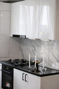 a kitchen with a stove and candles on a counter at White Pearl Residence in Roşu