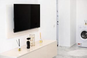 a living room with a tv on a white wall at White Pearl Residence in Roşu +6 photos