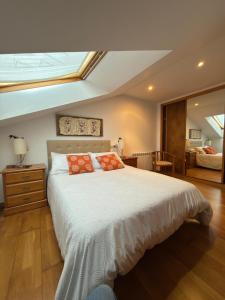 a bedroom with a large bed with orange pillows at Area 3B in Camariñas
