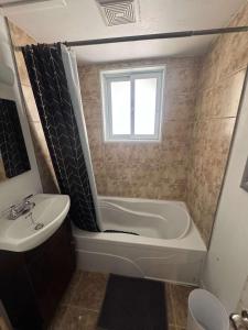 a bathroom with a tub and a sink at Condo ville de quebec in Quebec City