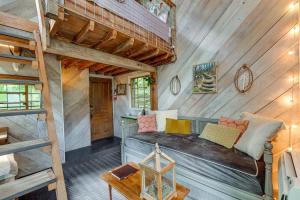 a bed in a room with a wooden wall at Treetop Hideaways: Luna Loft Treehouse in Flintstone