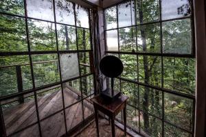 a room with large windows and a lamp on a table at Treetop Hideaways: Luna Loft Treehouse in Flintstone