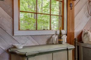 a bottle of wine sitting on a table under a window at Treetop Hideaways: Luna Loft Treehouse in Flintstone