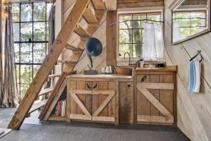a kitchen with wooden cabinets and a barn door at Treetop Hideaways: Luna Loft Treehouse in Flintstone +20 photos