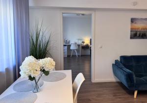 a living room with a table with flowers on it at Prime Host Sophie Deluxe Apartment in Karlsruhe