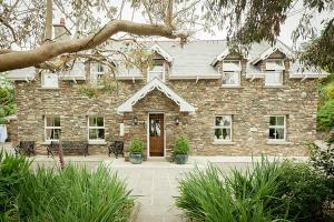 een groot stenen huis met een deur ervoor bij Lis-Ardagh Lodge in Union Hall