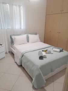 a bedroom with a large bed with towels on it at Eleni Apartment in Perdika