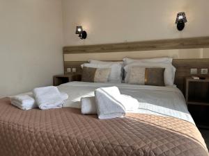 a bedroom with a large bed with towels on it at Airport Suites Michelle in Spata