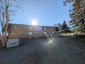 a building with the sun shining on top of it at Beaver Motel in Wawa