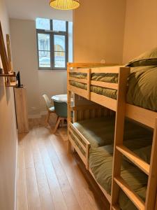 a room with two bunk beds and a table at Ninon et ses sommets in Cauterets