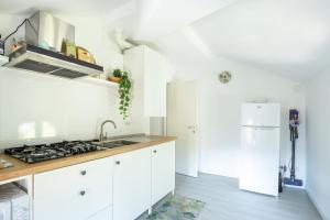 a kitchen with white cabinets and a sink at Elegante Attico Fronte Lago - Casa Barozzi in Luino