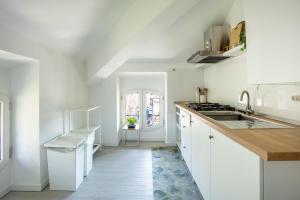 a kitchen with white cabinets and a sink at Elegante Attico Fronte Lago - Casa Barozzi in Luino