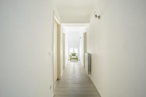 a hallway with white walls and a table in the distance at Elegante Attico Fronte Lago - Casa Barozzi in Luino