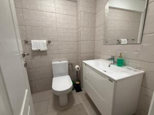 a white bathroom with a toilet and a sink at IDDA Concept 2 dormitoare 2 și living in Târgu-Mureş +30 photos