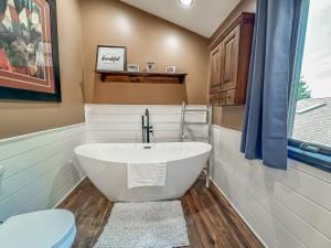 a bathroom with a white tub and a toilet at New: Lake Access with Dock Slip More in Swanton +42 photos