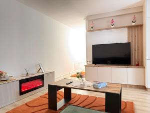a living room with a fireplace and a tv at IDDA Concept 2 dormitoare 2 și living in Târgu-Mureş