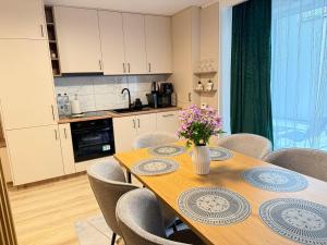 a kitchen with a wooden table with flowers on it at IDDA Concept 2 dormitoare 2 și living in Târgu-Mureş