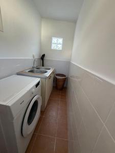 a small bathroom with a washing machine and a sink at Apollon Heritage House in Palaiókipos