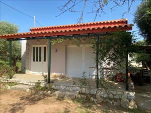 a small white house with a red roof at Epicurus beach cottage in Kánalos