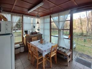 a kitchen with a table and chairs and a kitchen with a window at Chatičky pod Kamínkem Doksy in Doksy