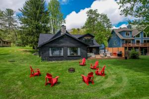 a yard with red chairs and a house at Modern Stunning Private Flat Lakefront in Oakland