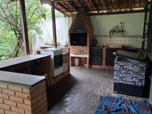 an outdoor kitchen with a brick oven and a fireplace at Sítio Limão Cravo in Areias