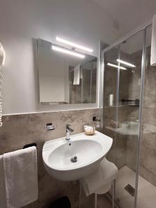 ein Badezimmer mit weißem Waschbecken und Dusche in der Unterkunft Hotel Al Capo in Varigotti + 50 Fotos