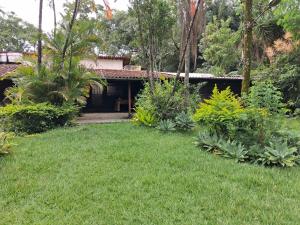 a house with a yard with green grass and plants at Sítio Limão Cravo in Areias