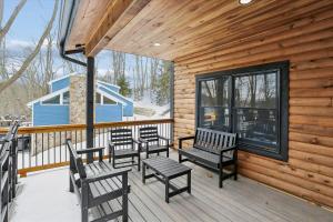 a porch with four chairs and benches on a cabin at Lakefront Private Indoor Pool New in Mountain Lake Park