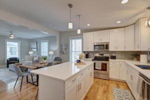 a kitchen with white cabinets and a living room at 25 OFF 1 Mile to IU Walk to Town in Bloomington