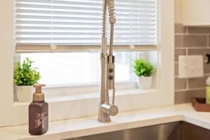 a kitchen sink with a bottle of soap next to a window at 25 OFF 1 Mile to IU Walk to Town in Bloomington