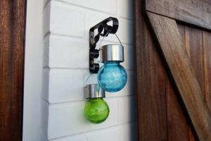 a green and blue glass bottle hanging on a wall at a l'aise aan zee in Koksijde