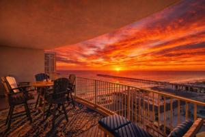 a view of the ocean from a balcony with a sunset at Amazing Sunsets Steps to Pier Park Heated Pool Hot Tub in Panama City Beach