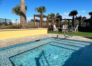 a swimming pool in a yard with a palm tree at Amazing Sunsets Steps to Pier Park Heated Pool Hot Tub in Panama City Beach