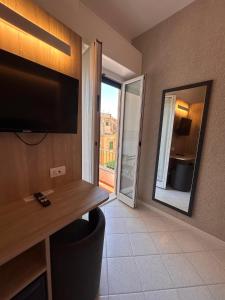 ein Hotelzimmer mit einem großen Flachbildfernseher an der Wand in der Unterkunft Hotel Al Capo in Varigotti