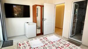a living room with a refrigerator and a television at Hedi Sozopol in Sozopol +22 photos