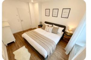 a bedroom with a large bed with white sheets and pillows at Apartment Heide in Soltau