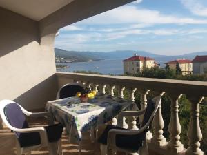 a table on a balcony with a view of the water at Apartments Cajic in Povile