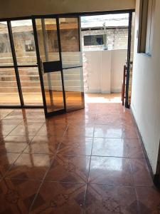 a room with a glass door and a tile floor at Casa Hotel Lunita in Iquitos
