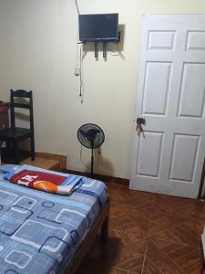 a room with a bed and a white door at Casa Hotel Lunita in Iquitos