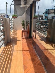 a balcony with a wooden floor and a chair at Casa Hotel Lunita in Iquitos