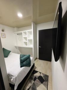a small bedroom with a bed and a black door at Edificio La Roca in Pereira