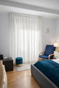 a bedroom with a bed and a blue chair at Luxury Double Room Marbella Center in Marbella