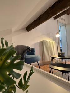 a living room with a blue chair and a table at Appartamento centro parma con ascensore BORGO 22 in Parma