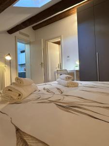 a bedroom with a large bed with towels on it at Appartamento centro parma con ascensore BORGO 22 in Parma +7 photos