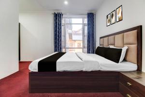 a bedroom with a large bed and a window at Hotel O Wave Inn in Srinagar