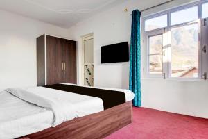 a bedroom with a large bed and a window at Hotel O Wave Inn in Srinagar