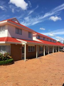a building with a red roof on a brick driveway at Ascot On Fenton in Rotorua
