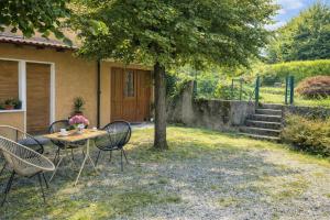 a table and chairs under a tree in a yard at Iris Peaceful Apartment near Lake Como and Lugano in Lanzo dʼIntelvi