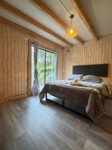 a bedroom with a bed and a large window at Tiny House A & M Chaiten in Chaitén